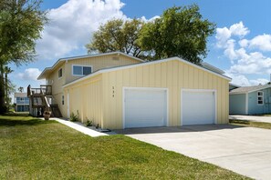 A two-story house with a garage, a staircase, and a well-maintained lawn. - Catch & Play on Estes Bay by Miss Kitty’s (Rockport)