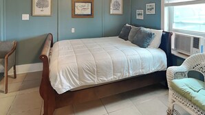 Ein Schlafzimmer mit einem Bett, einem Sessel und einem Fenster.