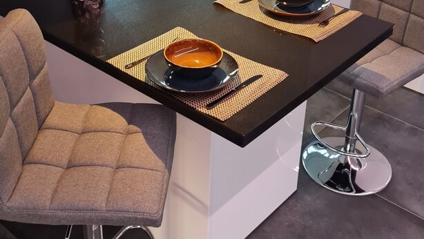 A modern kitchen with a central island, bar stools, and a decorative bronze bowl. - Luxurious apartment (new build) with feel-good guarantee.... Temporary living (Ispringen)
