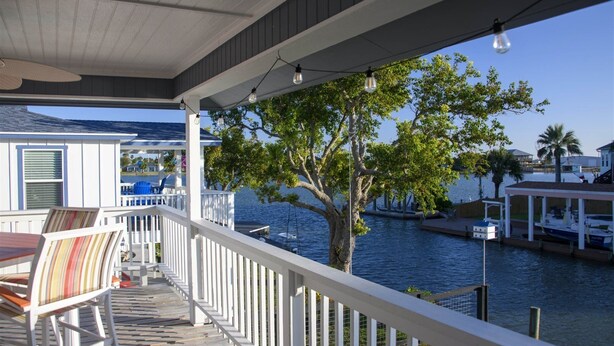 A covered deck with a view of a marina and water. - Bayside Blessing by Miss Kitty’s (Rockport)