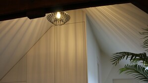 Een modern interieur met een schuine kap, een hanglamp en een houten vloer.