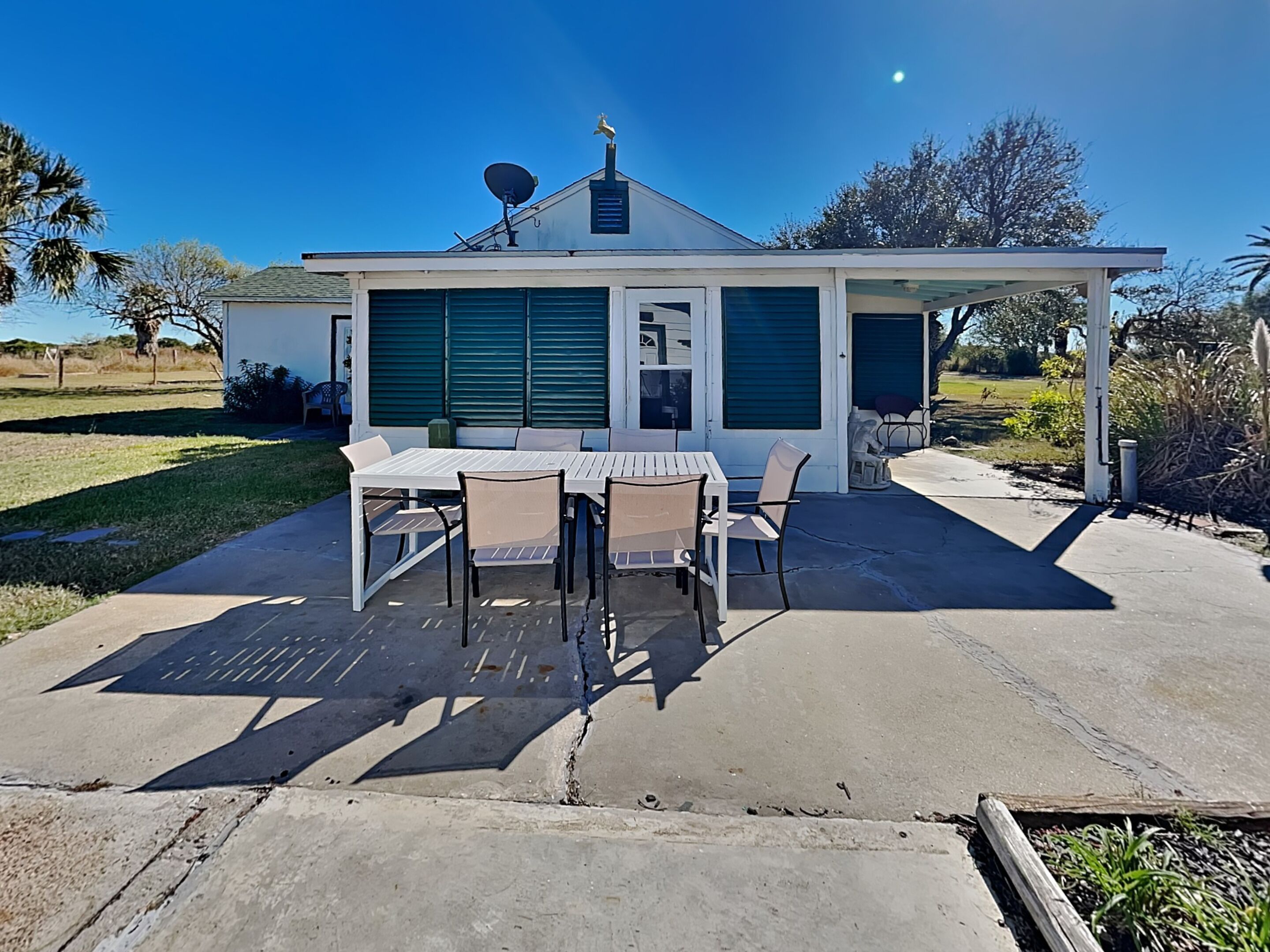 Une maison avec un patio, une table et des chaises.
