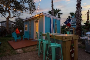 Relax on the wooden deck, surrounded by palm trees, and enjoy a refreshing drink at the bar.
