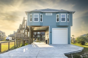 A two-story house with a garage, a covered porch, and a fenced yard.