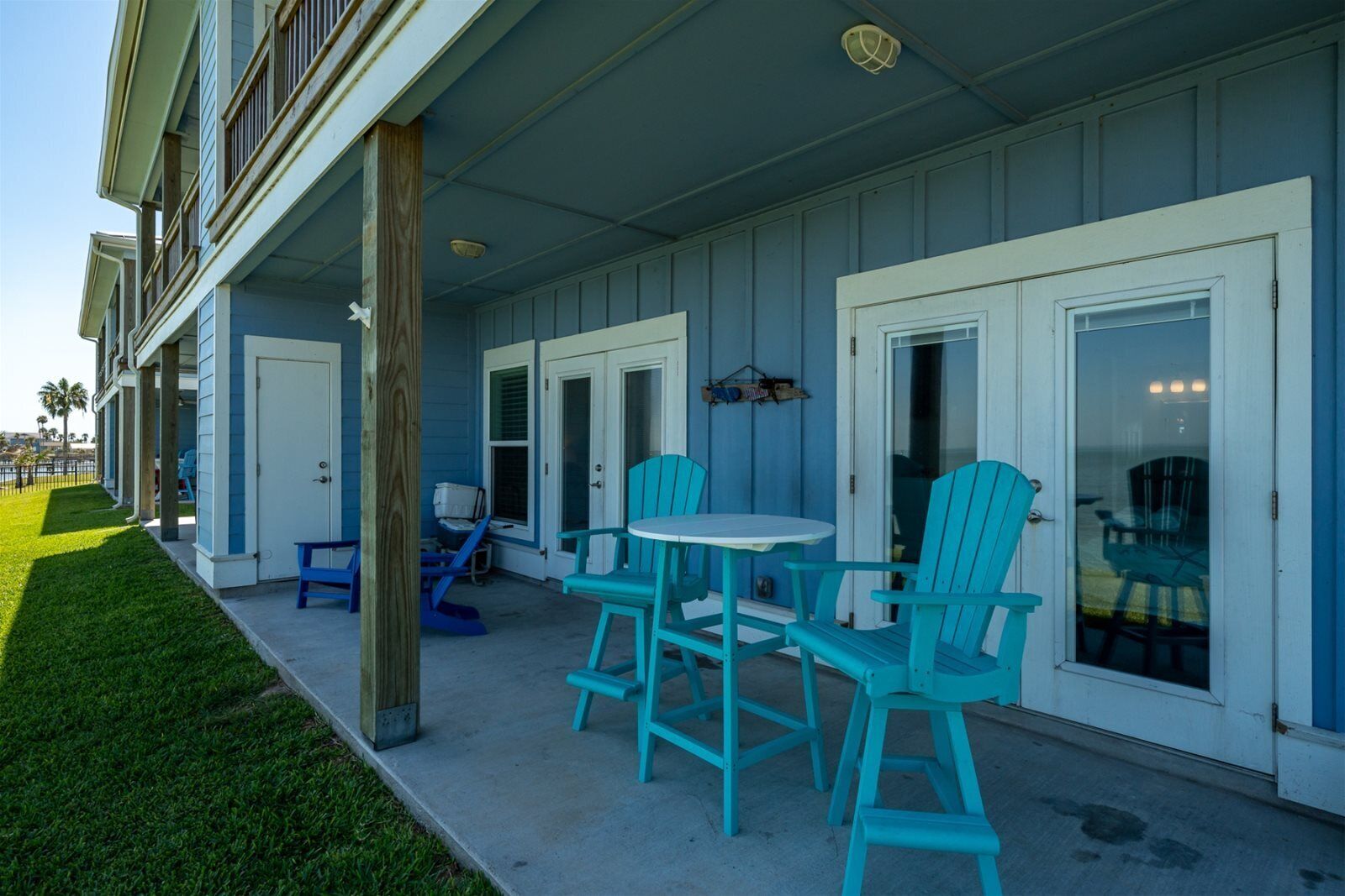 A building with a covered patio area featuring a table and chairs.