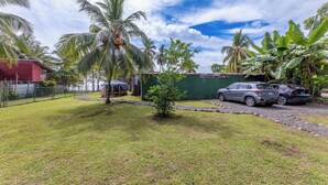 Bairro residencial com uma casa pequena, uma garagem e dois carros estacionados.