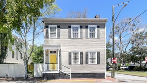 A two-story building with a yellow door, white siding, and multiple windows. - Artist's House Upper Apt Walk to Forsyth (Savannah)