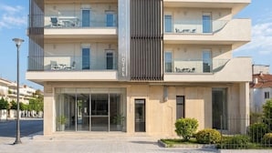 A multi-story hotel with a modern design, featuring balconies, large windows, and a prominent entrance. - Avra Hotel (Thermaikos)