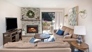 A living room with a fireplace, a television, and a sofa.