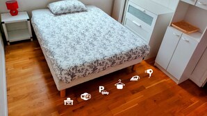 Ein Schlafzimmer mit einem Bett, einem Nachttisch, einem Heizkörper und einem Kleiderschrank.