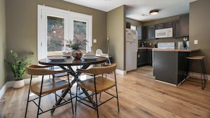 A modern kitchen with a central island, built-in appliances, and a dining area with a round table and chairs. - Peaceful Getaway, Sleeps 6・Hot Tub (Sevierville)