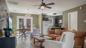 A modern living room with a sofa, armchairs, a coffee table, and a dining area with chairs and a table. - Peaceful Getaway, Sleeps 6・Hot Tub (Sevierville)