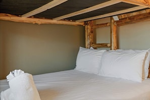 A single bed with white bedding in a room with wooden beams and a plain wall. - Sevierville Family Retreat with Private Hot Tub and Mountain Fun (Sevierville)