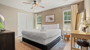 A bedroom with a bed, a desk, a chair, a ceiling fan, and a window. - Peaceful Getaway, Sleeps 6・Hot Tub (Sevierville)