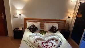 A bed with a heart-shaped decoration and the word "WELCOME" on the bedspread. - Arianna Dhangethi (Dhangethi)
