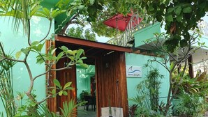 A small, single-story building with a wooden door and a small porch area. - Arianna Dhangethi (Dhangethi)