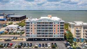 Un hotel de varios pisos con un atrio central, estacionamiento y vistas al agua.