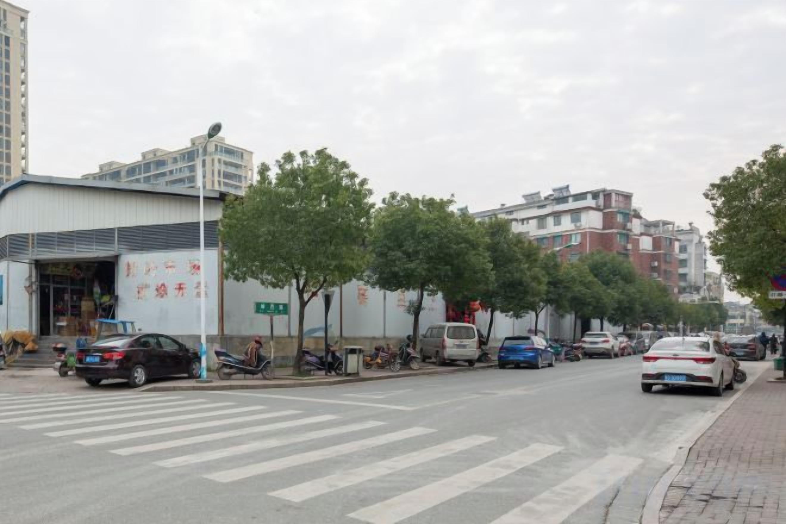 A street with buildings, cars, and trees.