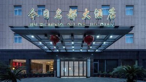 A hotel entrance with a modern design, featuring a glass canopy and a sign in a foreign language. - Jin Ri Ming Du Hotel (Lanxi)