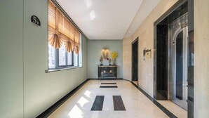 A hallway with a number sign, a reception desk, and an elevator. - Jin Ri Ming Du Hotel (Lanxi)