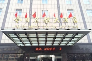 Un hotel con fachada moderna, que presenta un letrero destacado con caracteres chinos y banderas rojas.