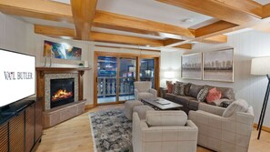 A living room with a fireplace, a television, a sofa, and a coffee table.