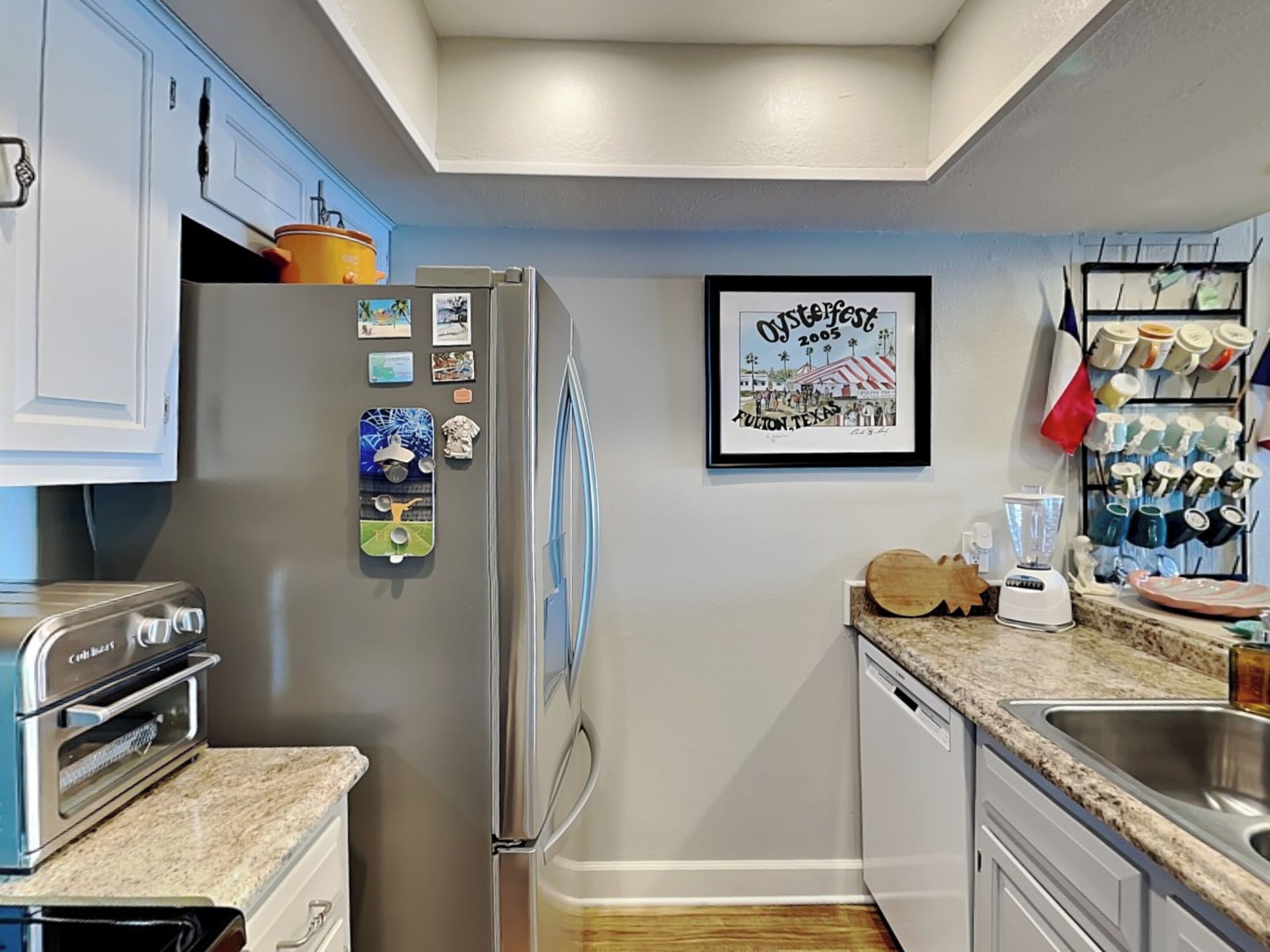 A compact kitchen with a built-in oven, a refrigerator, and a coffee maker.