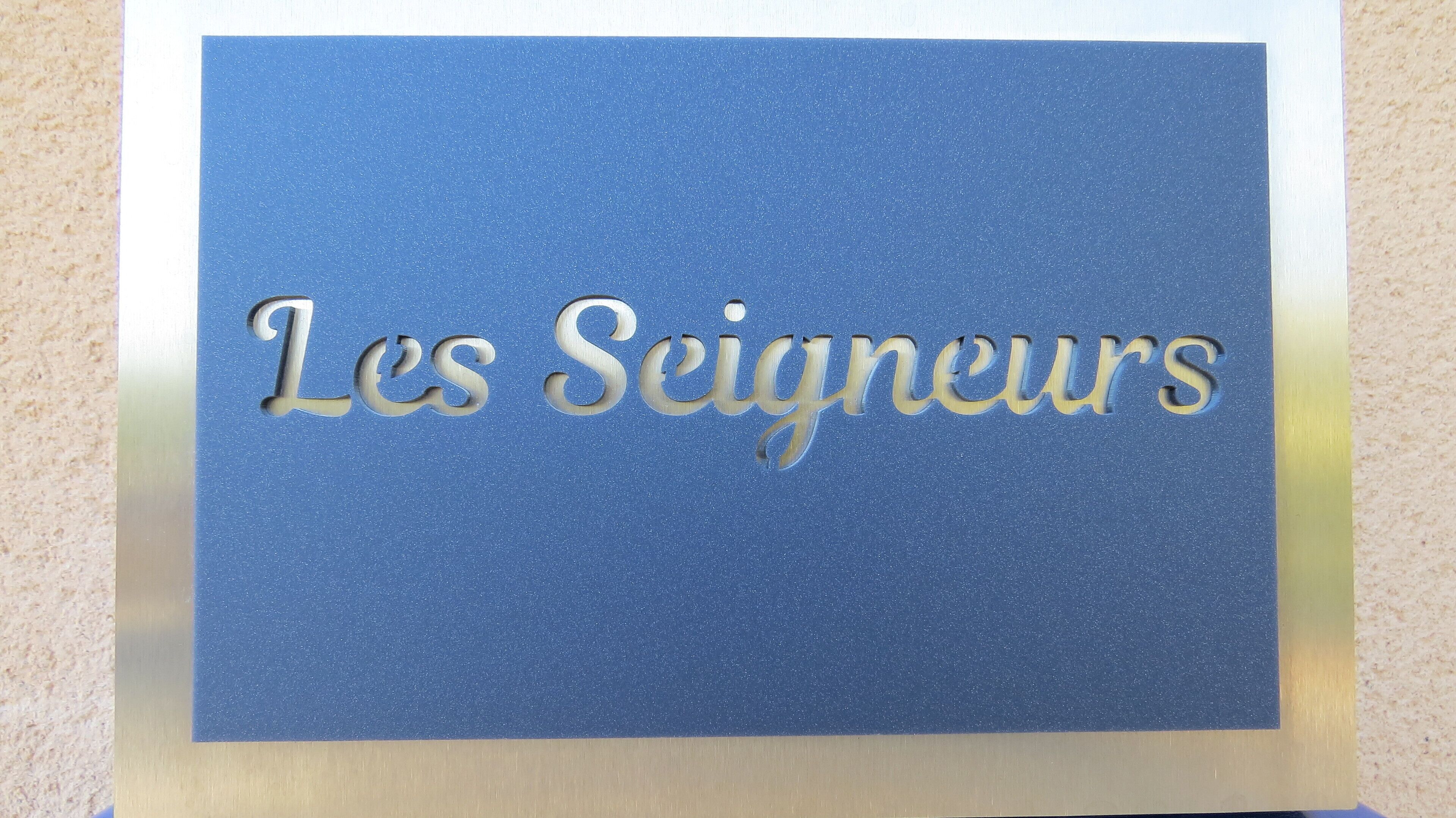 Une enseigne avec l’inscription « Les Seigneurs » sur un fond bleu.