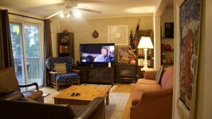 A living room with a television, sofa, coffee table, and a fireplace.