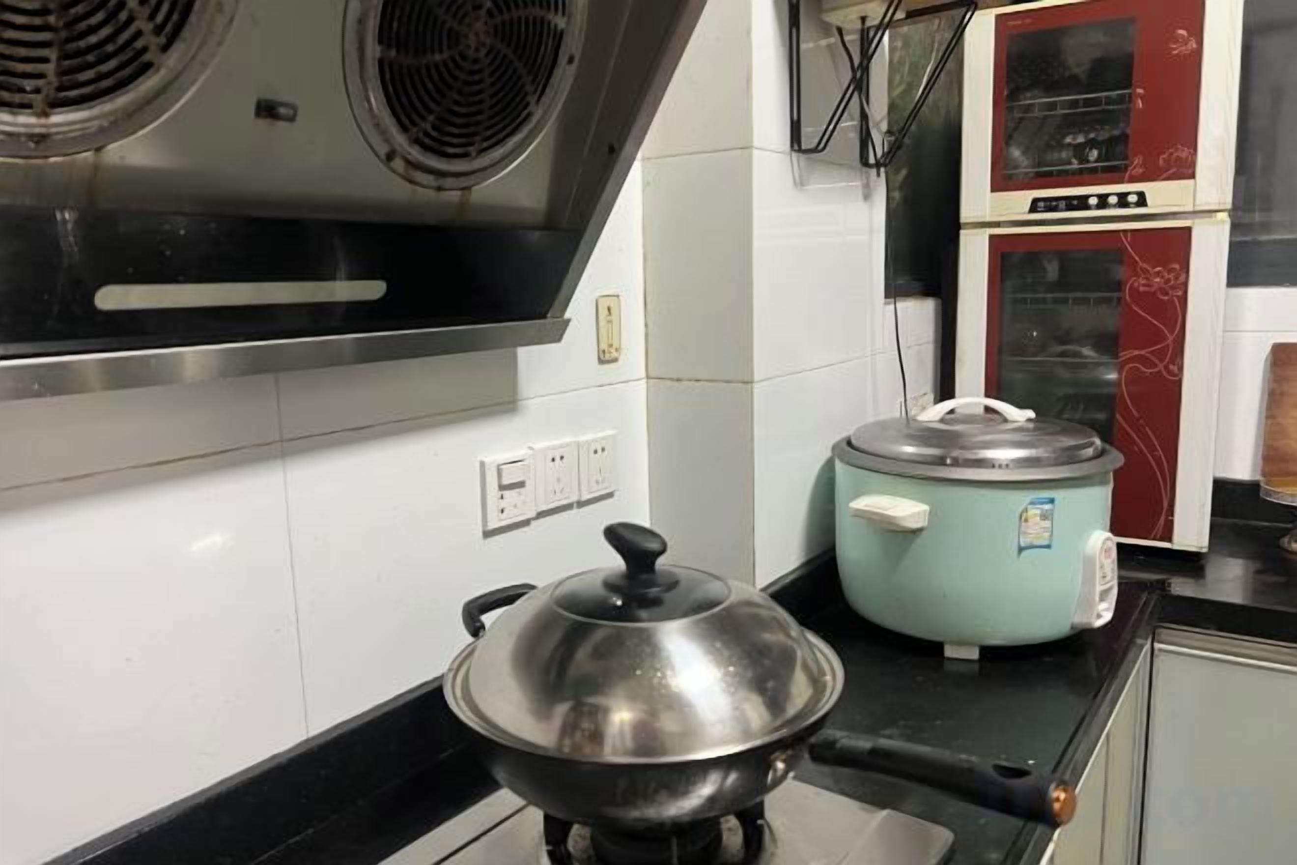 Une cuisine équipée d’une cuisinière, d’une mijoteuse bleue et d’un four rouge.