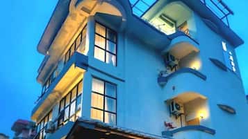 A multi-story building with balconies and windows, featuring a curved architectural design.