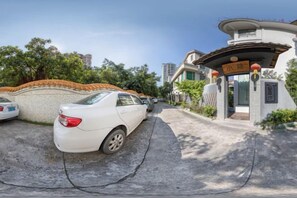 A gated entrance to a residential area with a white car parked in the driveway. - Taoshe Hotel (Guangzhou)