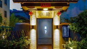 Une porte chinoise traditionnelle, sur laquelle on peut lire l’inscription « 小隐 » (Xiao Yin), et surmontée d’une lanterne rouge.