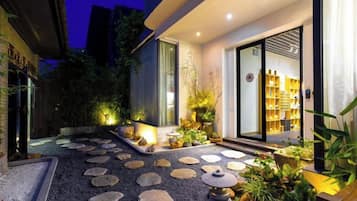 Facciata moderna di un edificio con un vialetto in pietra che conduce a un ingresso con porta in vetro.