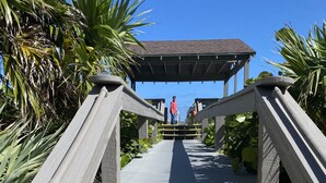 A wooden staircase with yellow handrails leading to a covered area.