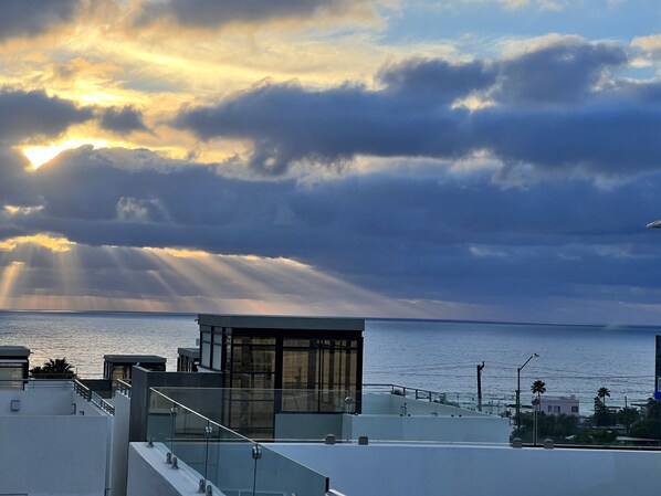 A modern building with a glass facade overlooking a body of water.