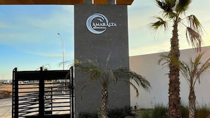 A modern building with a sign reading "AMARALTA RESIDENCIAL". - 3BR 10 Guest with Pvt. Jacuzzi 2 pools Gated Comm. AC Security 24-7 (Rosarito)