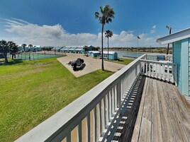 A view of a hotel with a pool, a covered area with equipment, and a deck with a railing.