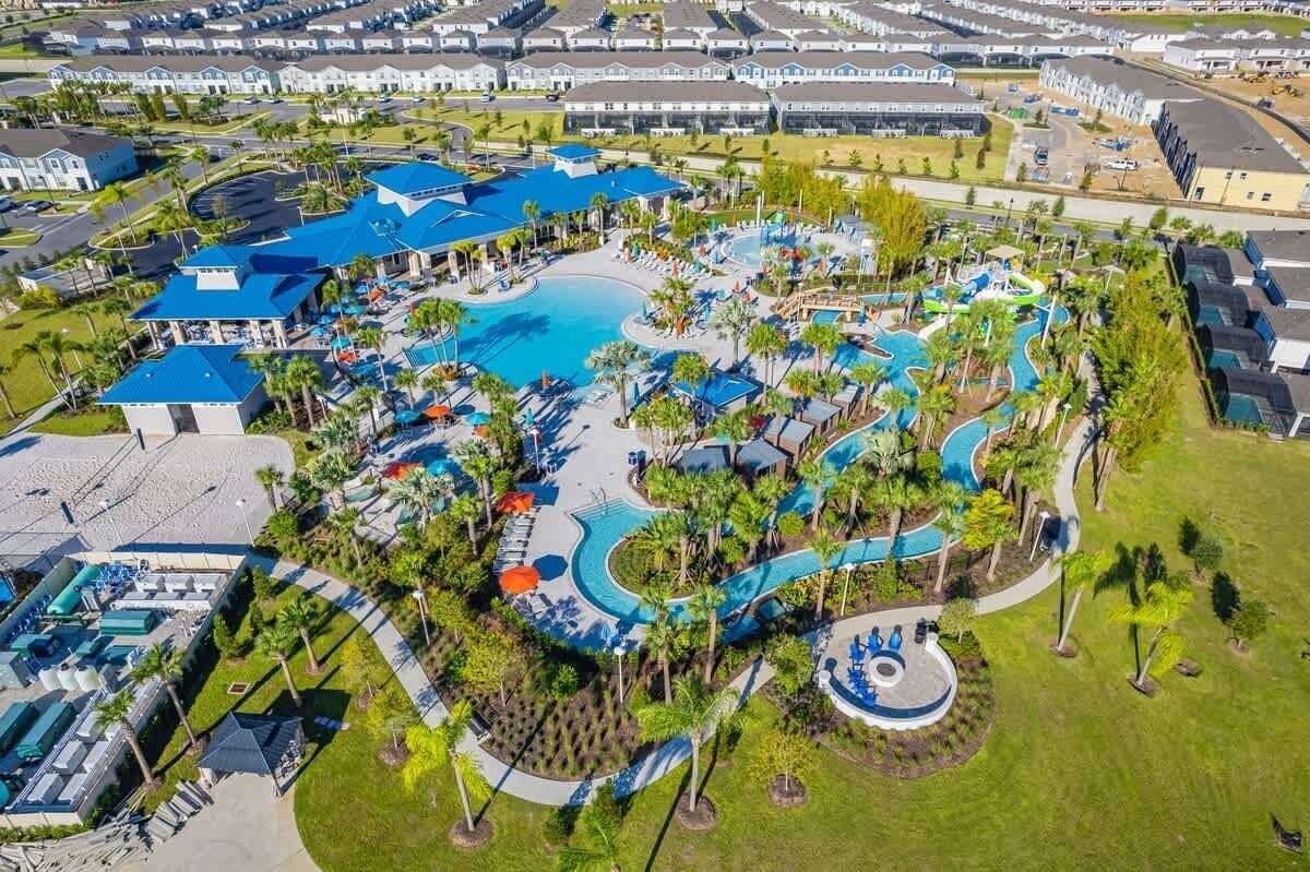 An aerial view of a resort with a large central pool, multiple smaller pools, and a variety of outdoor and indoor amenities.