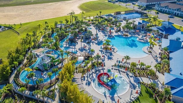 A resort with multiple swimming pools, water slides, and lounge areas surrounded by palm trees. - Paradise Resort (Davenport)