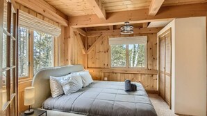 Une chambre à coucher avec un lit, une table de chevet et une fenêtre avec des stores.