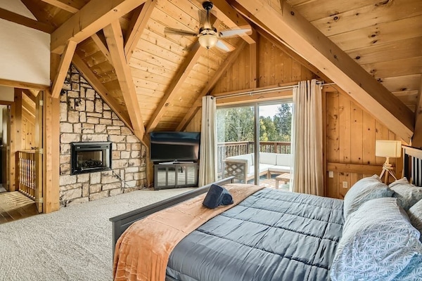Master Suite - King bed, private balcony, private bathroom, walk in closet, electric fireplace, and 55 inch curved TV.