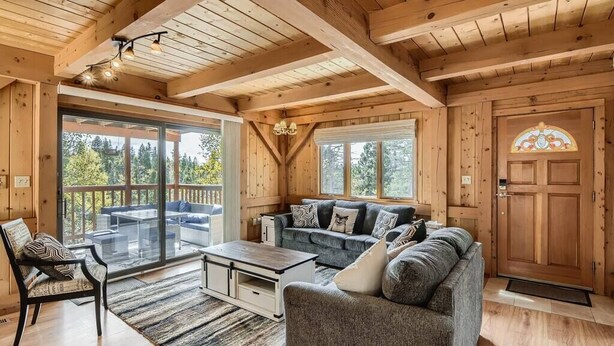 L’intérieur d’un chalet en bois chaleureux et accueillant comprend un espace de vie avec un canapé, une table basse et une table à manger.