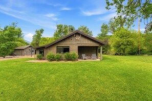 A two-story house with a covered porch, a garage, and a well-maintained lawn.