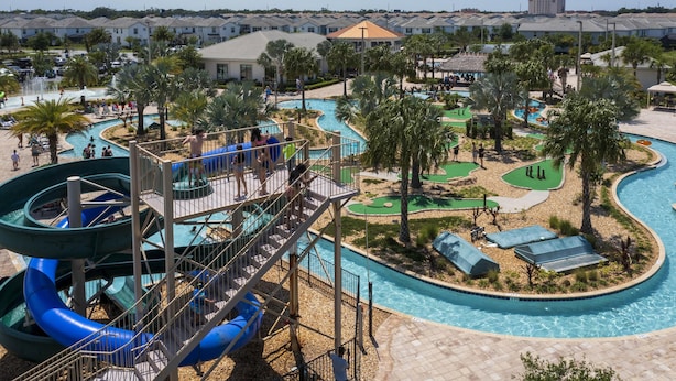 Ein Wasserpark mit Rutschen, einem Pool und Palmen.