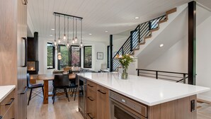 Una cocina moderna con una isla central, armarios de madera y horno empotrado.