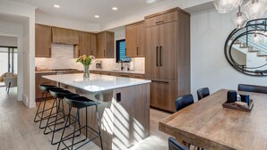 Una cocina moderna con una isla central, armarios de madera y taburetes de bar.