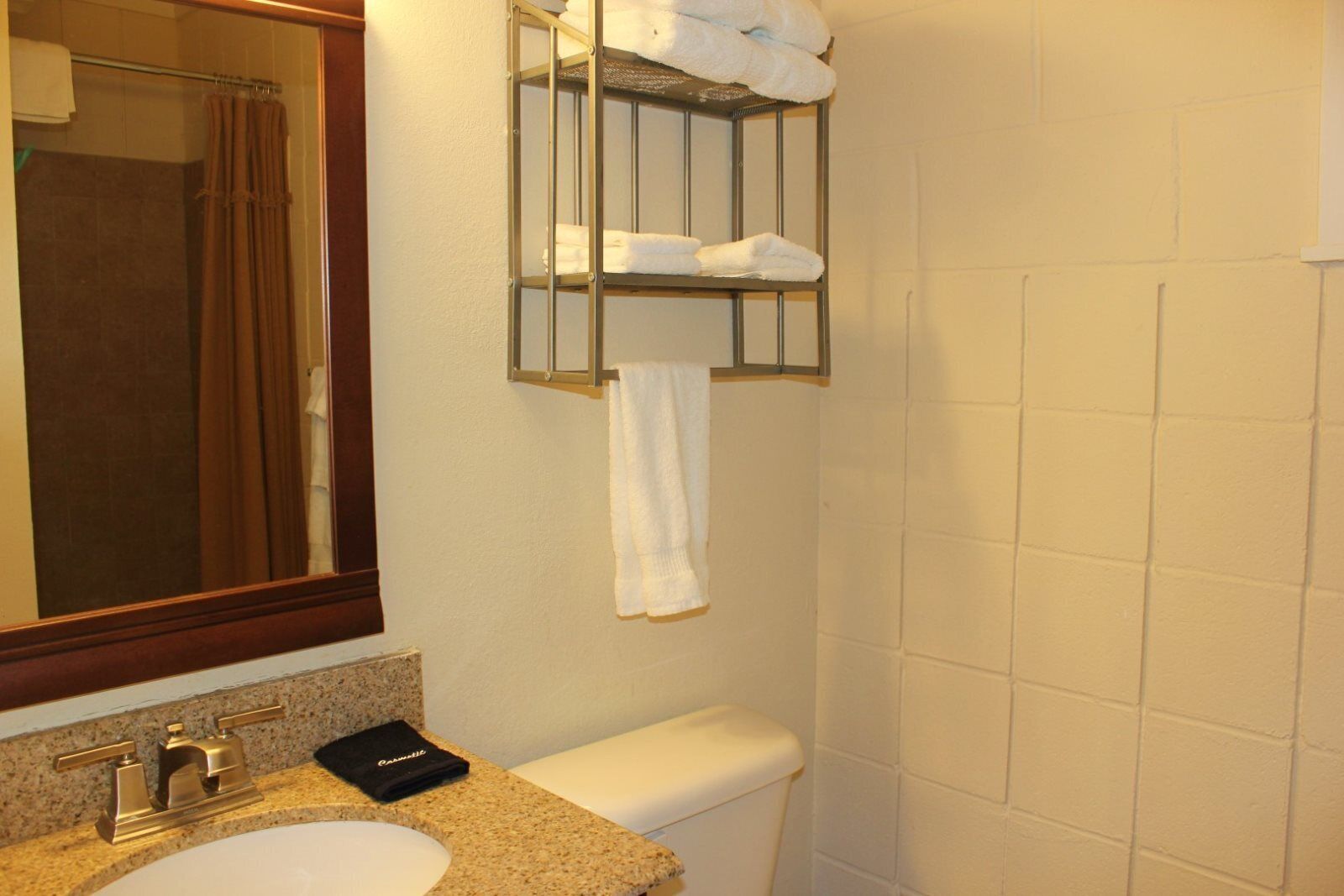 Une salle de bain équipée d’un lavabo, d’un miroir, d’un porte-serviettes et de toilettes.
