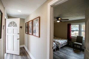 A bedroom with a bed, a chair, a ceiling fan, and a window. - Deep Water Dock and Home on the GA Coast (Midway)