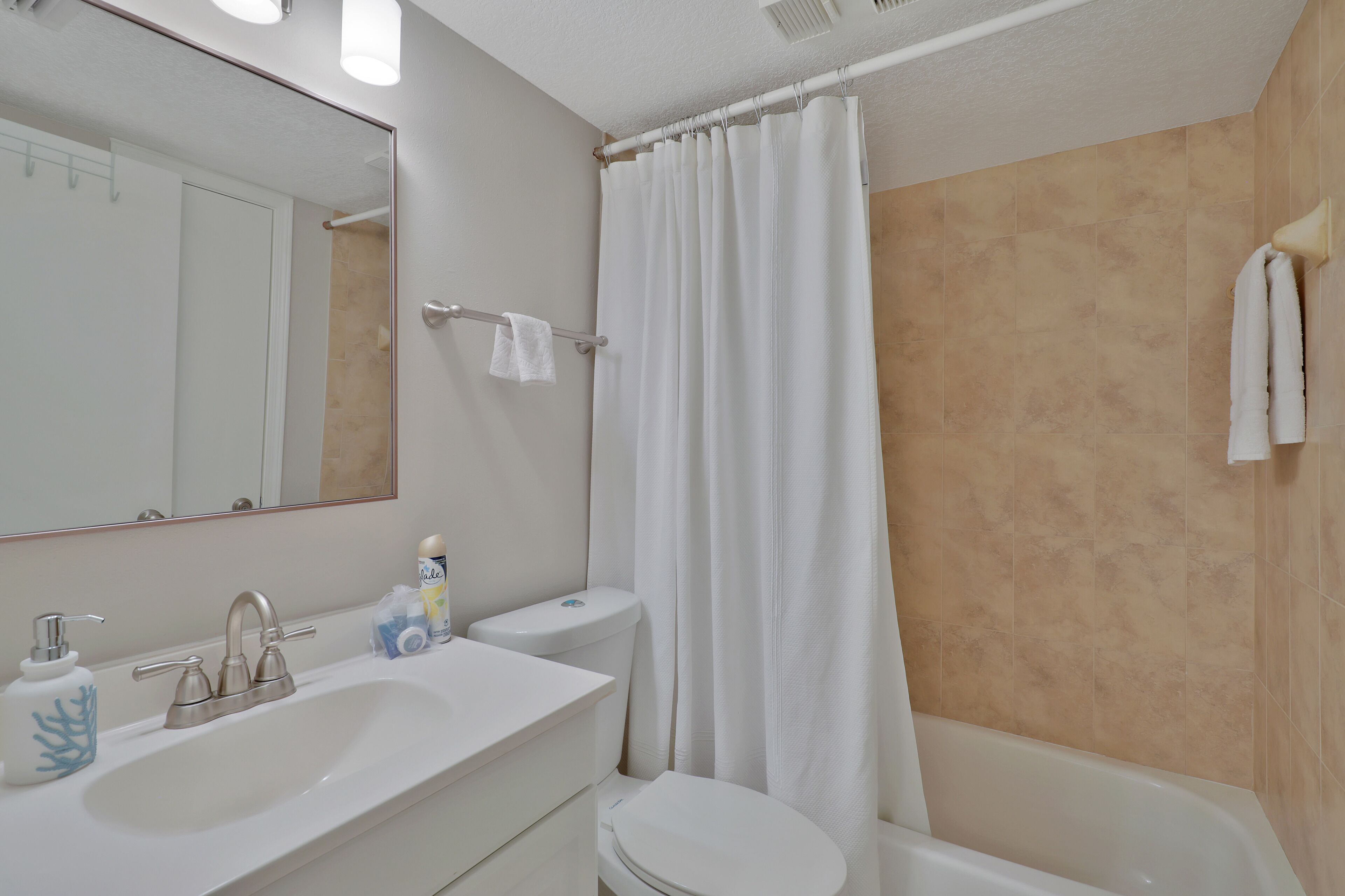 A bathroom with a white sink, toilet, and bathtub.